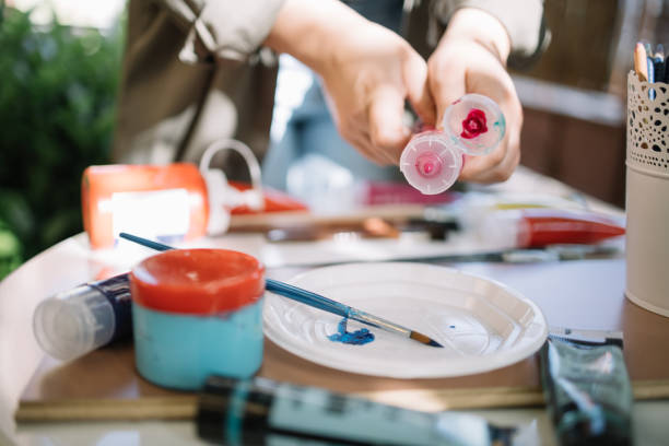 istock Female hands squeezing red aquarelle paint tube 1262630895