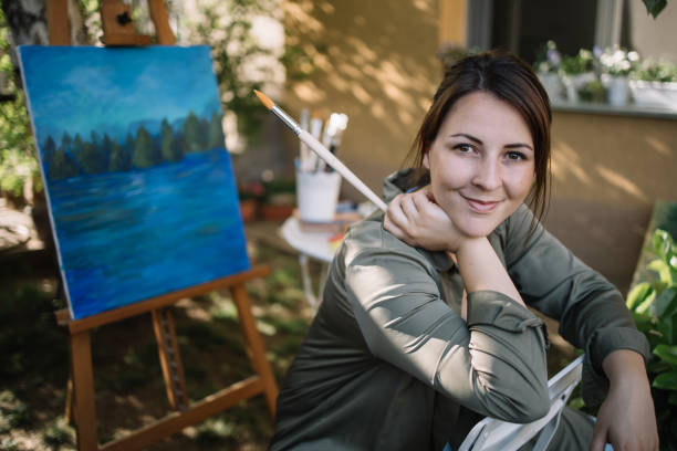 istock Lady sitting in garden art studio and looking at camera 1262632600