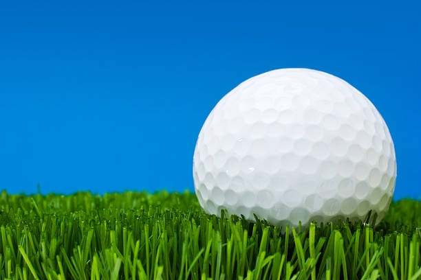 istock Golf ball in perfect grass against blue background 126263294
