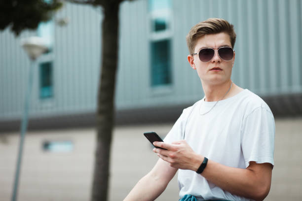 istock Handsome young guy sitting on a bench with a smartphone on the internet 1262633384