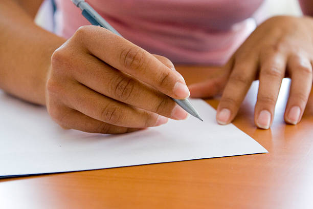 Close-up of adult hands writing with pen and paper stock photo