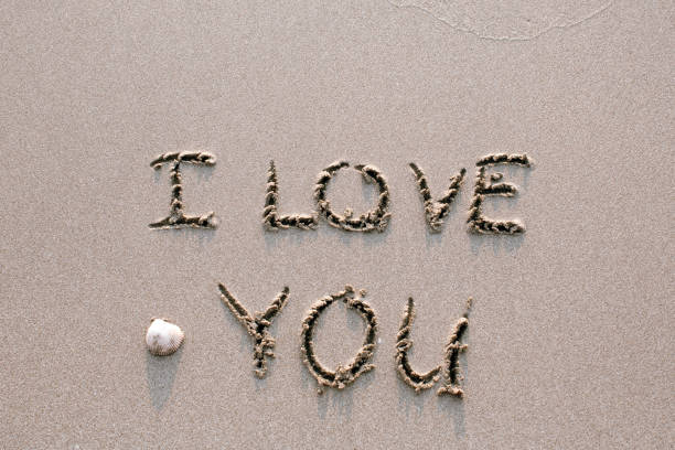 I Love You - drawn on sand beach with the wave.