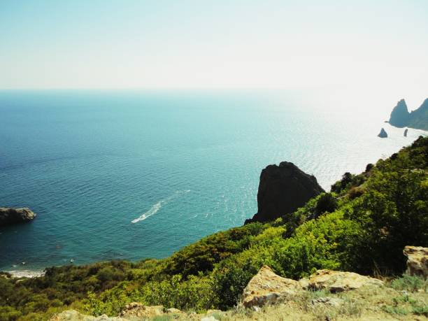 View of the Black Sea from a high cliff in summer time. Blue water, speed boat, nice view. Krimea.