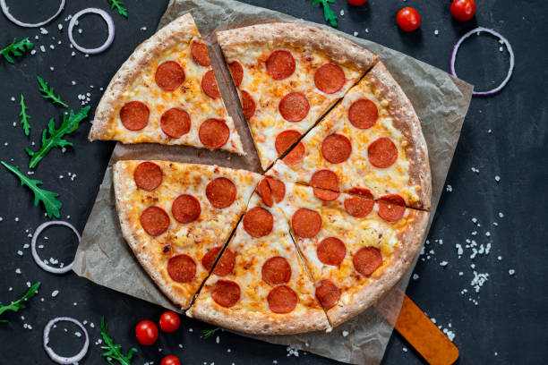 istock Pizza pepperoni with mozzarella on wooden board on a black background 1262639977