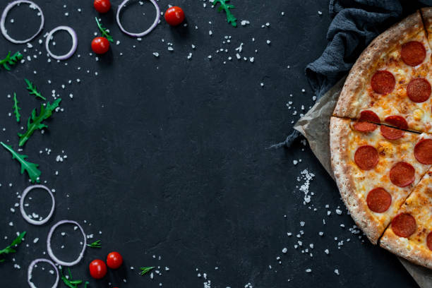 istock Pepperoni Pizza On Black Background With Cooking Ingredients and Empty Space For your text 1262639984