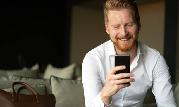 istock Happy young man using his smart phone at office 1262640110