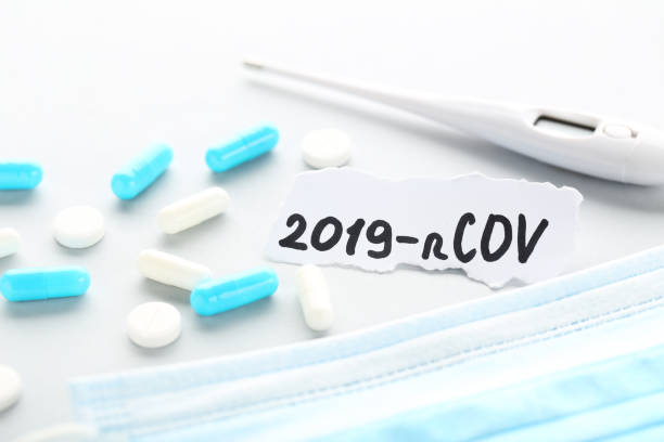 istock Text 2019-nCov with pills, medicine mask and thermometer on grey background 1262640198