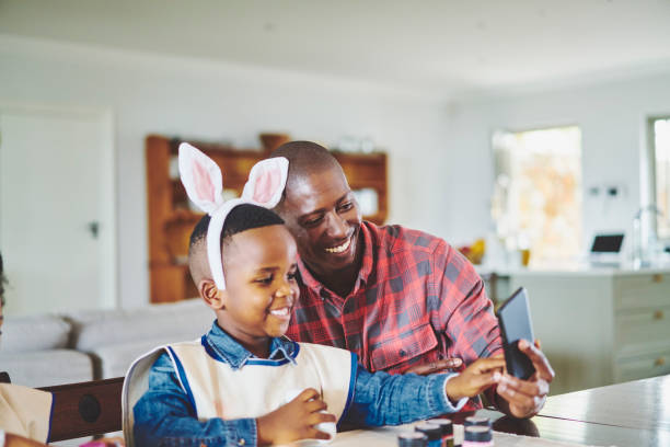istock Father taking a selfie with his cute little son wearing rabbit ears 1262645362