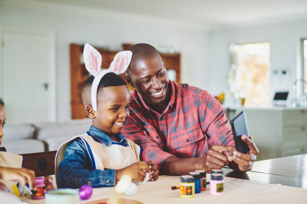 Father taking selfies with his cute little boy wearing rabbit ears