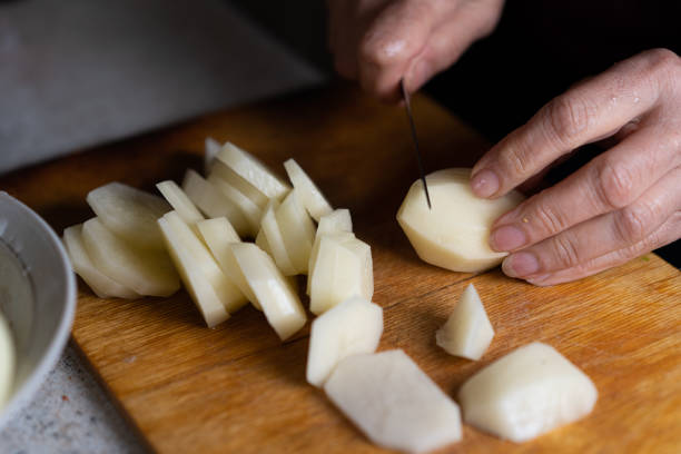 istock Slicing potatoes on a cutting board 1262648826
