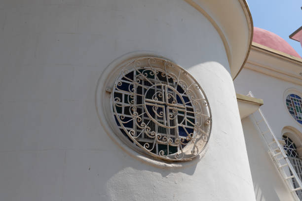 parrilla decorativa metálica en la ventana de la iglesia de los apóstoles situada a orillas del mar de galilea, no muy lejos de la ciudad de tiberíades, en el norte de israel - greek culture bible text ancient fotografías e imágenes de stock