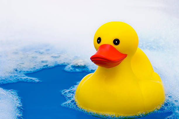 istock Yellow rubber duck swimming in water with bubbles 126264905