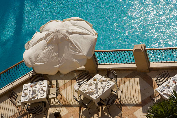 tavole a bordo piscina - umbrella poolside table dining foto e immagini stock