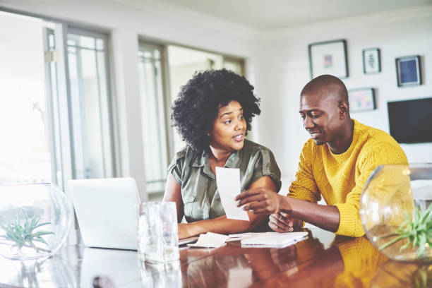 istock Smiling couple sitting at a table and going over their household finances 1262652251