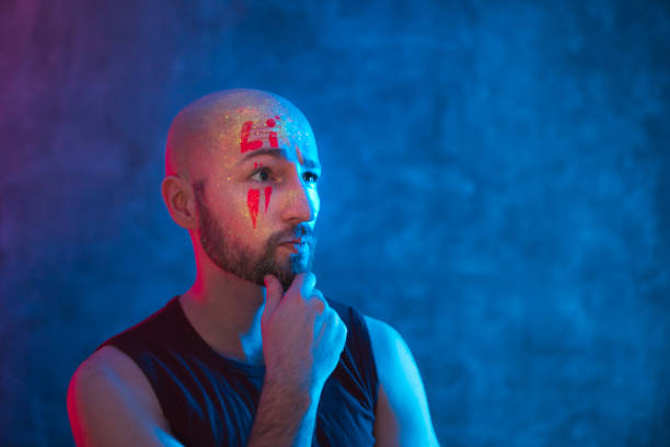 istock Portrait of man with fluorescent drawings on face. 1262656046