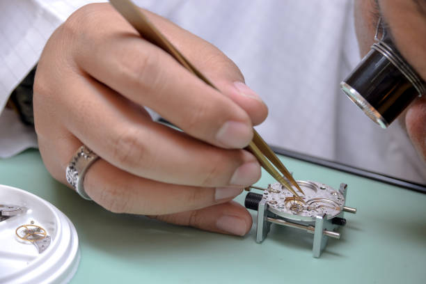 istock Watchmaker picked up the tiny escape wheel part very carefully to mainplate 1262663197