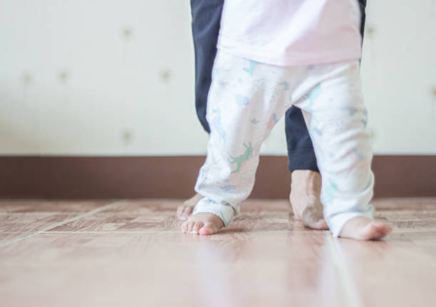 istock Baby Girl Doing First Steps With Mothers 1262669102