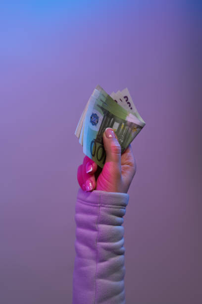 istock Hand holding banknotes on violet background. 1262669127