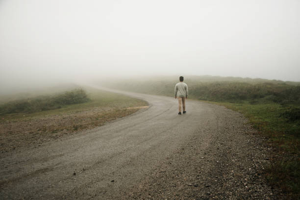 istock Man walking on a foggy road 1262670550