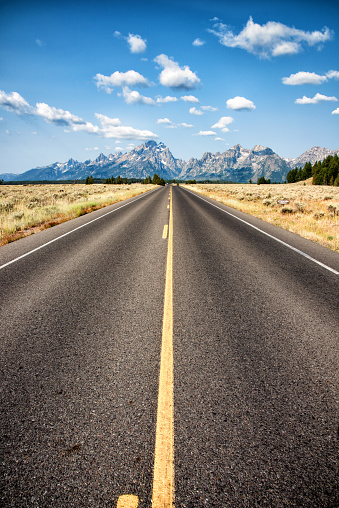 A long stretch of highway into Grand Teton National Park, Wyoming, USA.