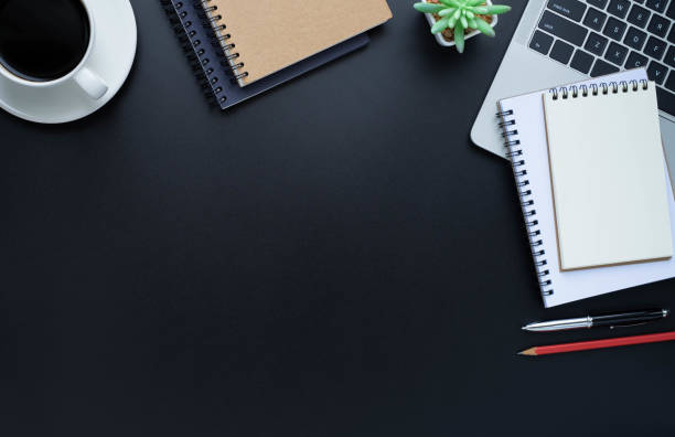 istock Black office desk table with laptop, notebook and coffee cup with equipment other office supplies. Business and finance concept. Workplace, Flat lay with blank copy space, Top view. 1262671842
