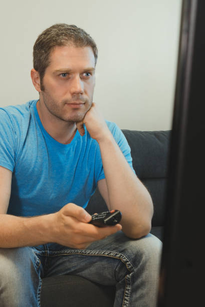 istock Handsome man watching big lcd TV at home. 1262673873