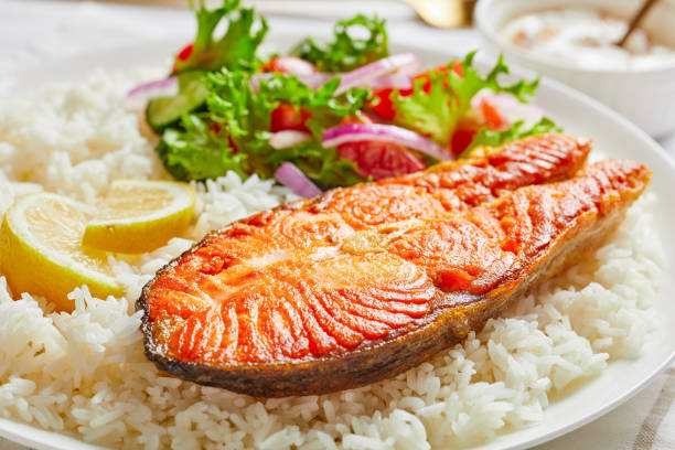 istock fried trout steak served with rice and vegetable salad 1262674480