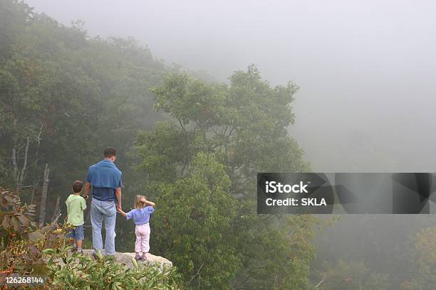 Escursione Famigliapadre Con Due Bambini In Piedi Sulla Roccia - Fotografie stock e altre immagini di Adulto