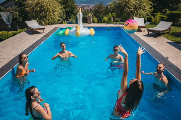 amis jouant au volley-ball dans la piscine - beach ball swimming pool ball child photos et images de collection