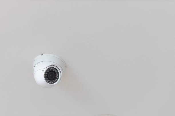 istock Security CCTV camera surveillance system indoor of house. A blurred night Cityscape background. Modern CCTV camera on a wall. Equipment system service for safety life or asset. 1262683529