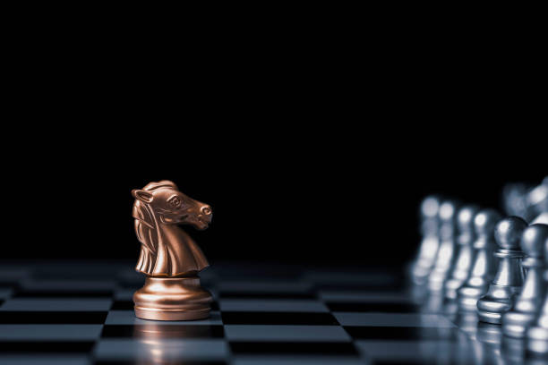 istock Golden horse chess encounters with silver chess enemy on chess board and black background. Market or business competitor concept. 1262684256