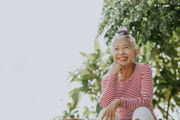 verticale de hipster aîné thaï à côté du jardin - thai ethnicity photos et images de collection