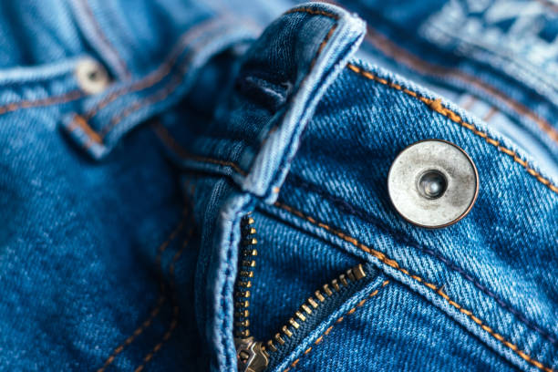 istock Jeans front with zipper open. Bright blue denim fabric texture background. Closeup view. Selective focus 1262687154