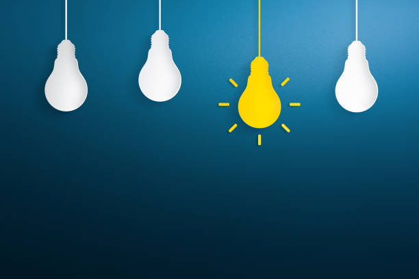 istock Yellow paper light bulb on blue background. Creative idea, new idea and innovation concepts. 1262687806