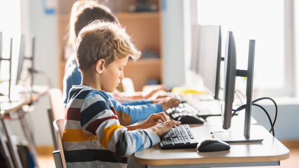 小学校のコンピュータサイエンス教室:かわいい男の子は、ソフトウェアコーディングのためのプログラミング言語を学習し、パーソナルコンピュータを使用しています。現代教育を受ける小 - elementary student little boys classroom child ストックフォトと画像