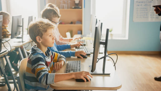 istock Elementary School Computer Science Classroom: Diverse Group of Little Smart Schoolchildren using Personal Computers, Learn Informatics, Internet Safety, Programming Language for Software Coding 1262689314