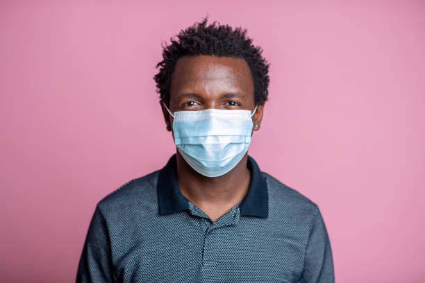 istock African-American young man with protective face mask looking at camera with a smile 1262691941