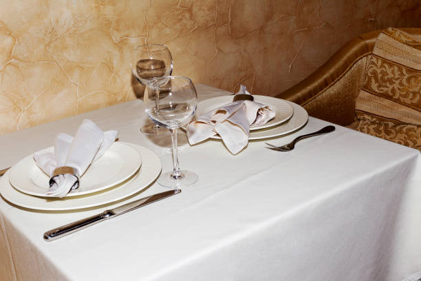 istock Elegant table setting with fork, knife and white napkin for two persons. A cozy cafe. 1262695896