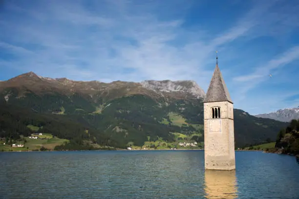 Campanile di curon venosta vecchia or Submerged tower of reschensee church deep in Resias Lake at morning in Trentino-Alto valley in South Tyr or Alto Adige in Bolzano or bozen city at Italy