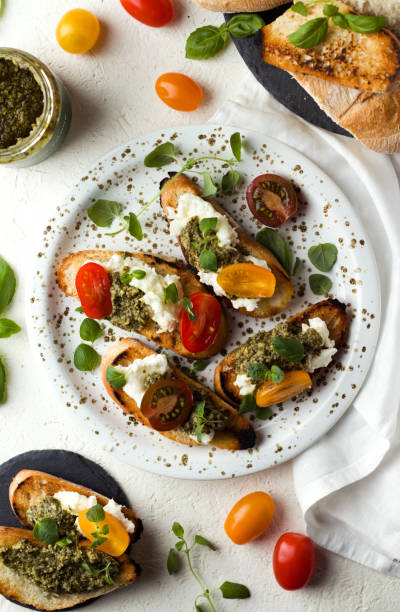 istock Bruschetta with cheese, pesto, basil and tomato on a plate on a white background, top view 1262699282
