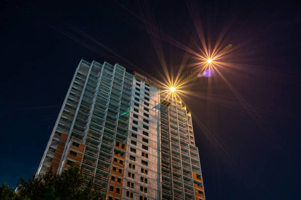 istock Tower crane at a construction site at night. 1262703938