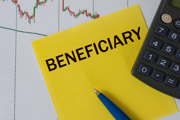 istock BENEFICIARY word on yellow sheet on table with pen, calculator and graph 1262705828