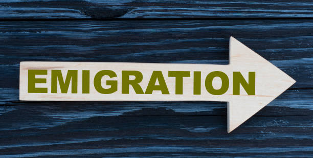 istock EMIGRATION word written on a wooden arrow on a beautiful dark background 1262706270
