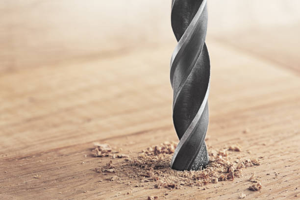 istock drill makes a hole in the wooden oak table with wood 1262706877