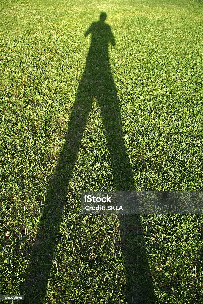 Tall Shadow Man - shadow on green grass  Abstract Stock Photo
