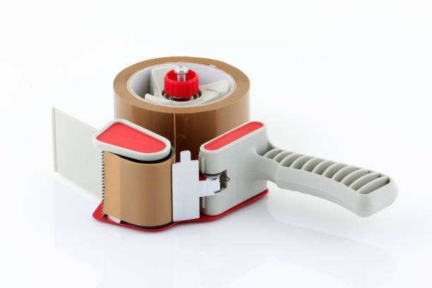 Parcel tape dispenser laid on white background A Parcel tape dispenser laid on white background nigel pack stock pictures, royalty-free photos & images