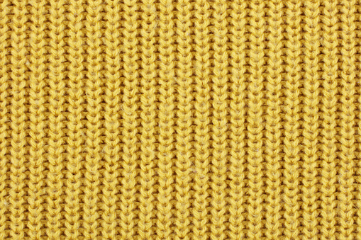 A yellow knitted ribbed wool textile background texture