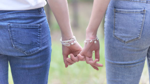 istock Two women holding hands in a park 1262727750