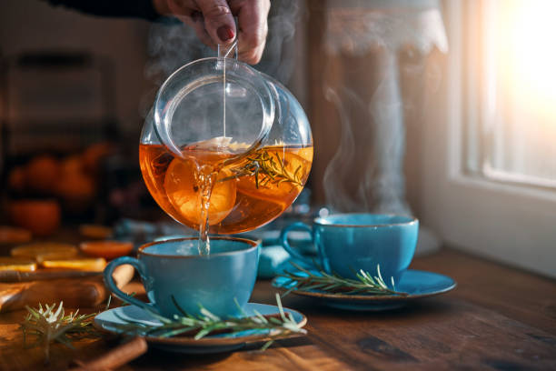 Fruit Tea with Oranges, Cinnamon and Rosemary Fruit Tea with Oranges, Cinnamon and Rosemary afternoon tea photos stock pictures, royalty-free photos & images