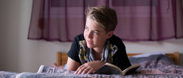 istock Teenage boy is reading a book 1262733761